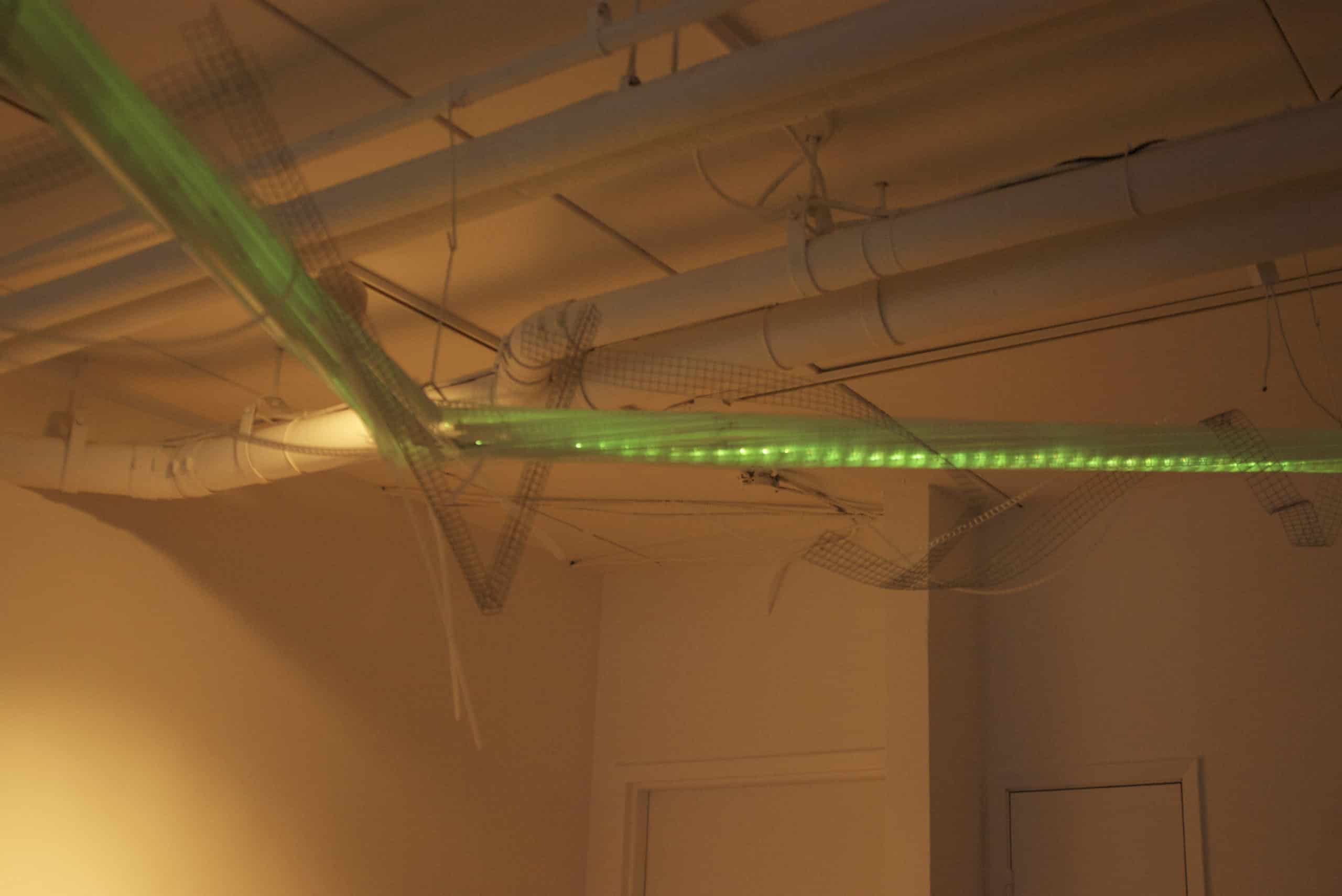 22-foot-long pendant LED light sculpture, changing colours.  LED lights run through three acrylic tubes joined with heavy gauge wire, wrapped with strips of steel mesh and polycarbonate.  stunning; completely original.