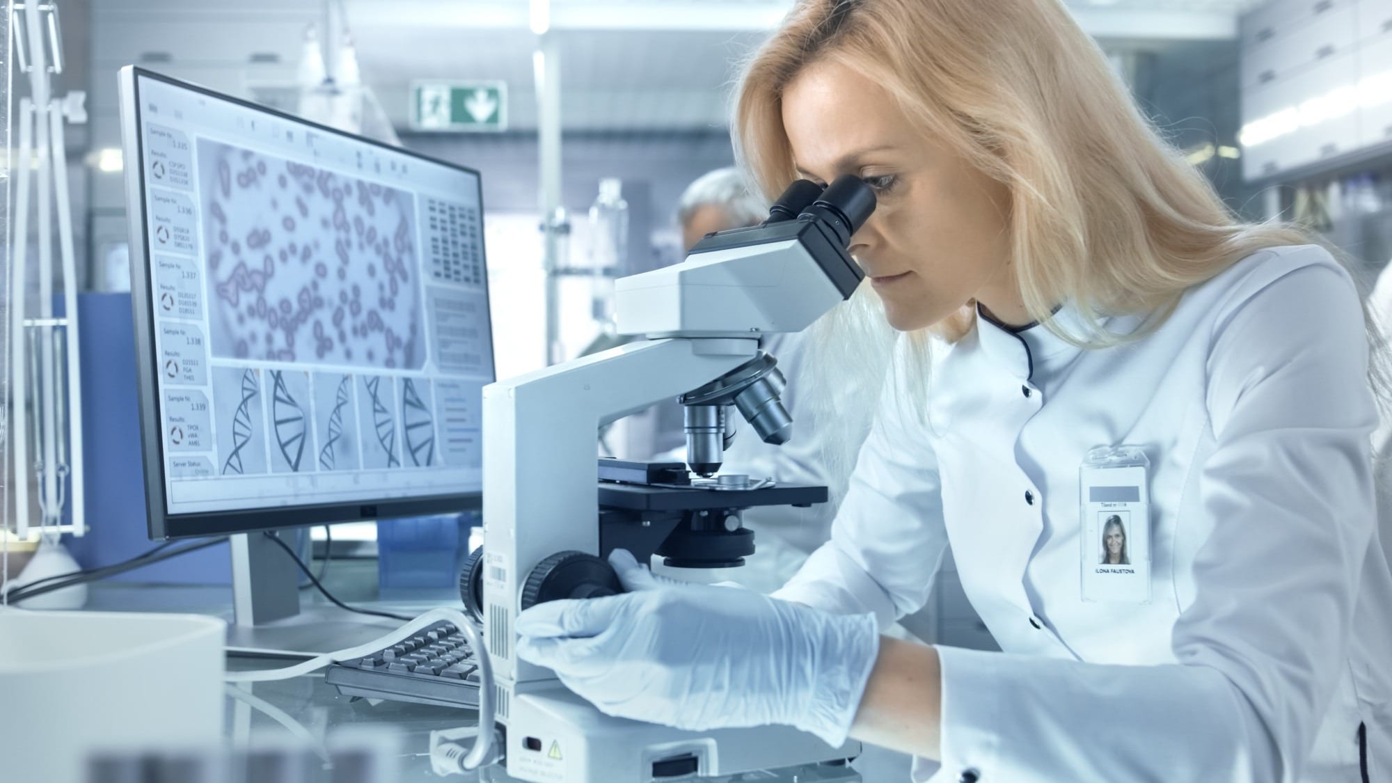 Female Research Scientist Looks at Biological Samples Under Microscope