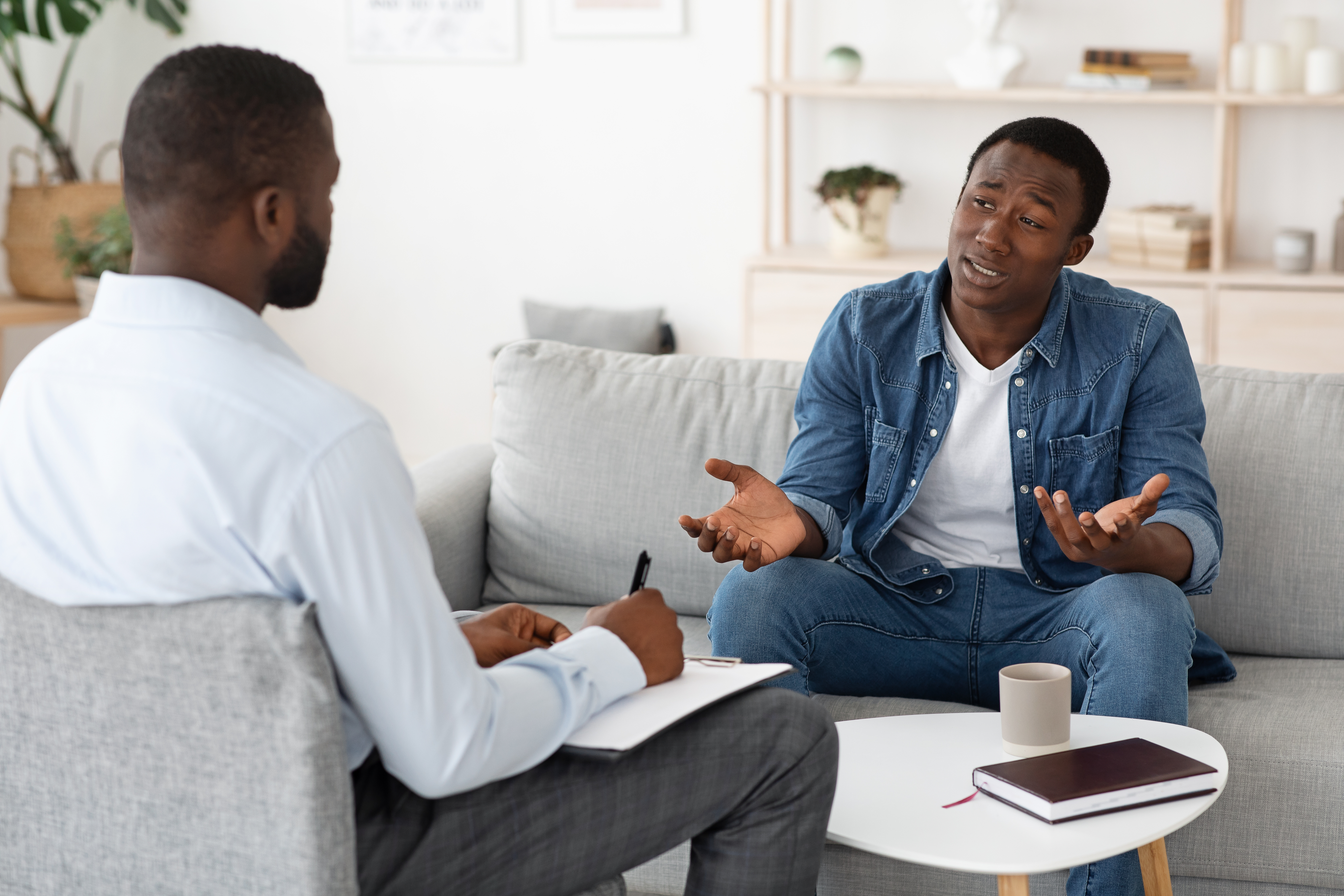 Stressed black man explaining his problems to psychologist at
