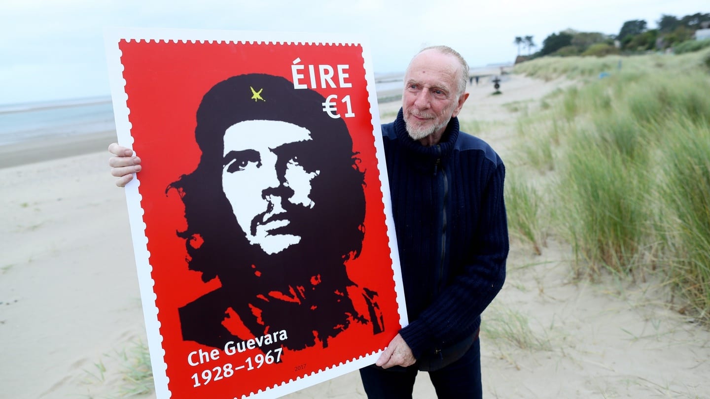 Irishartist Jim Fitzpatrick with a promotional image of a stamp featuring his world famous image of Che Guevara [Irish Times]