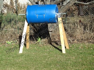 DIY compost bin made from a 55 gallon drum. Elevated legs make it easy to fill a wheelbarrow with compost.