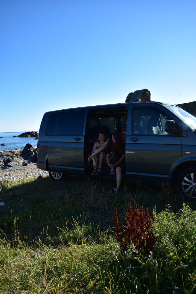 Two people sitting in a van at Salmon Howie Beach, Aberdeenshire, Scotland