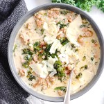 overhead photo of creamy soup made with italian sausage and kale and topped with parmesan cheese