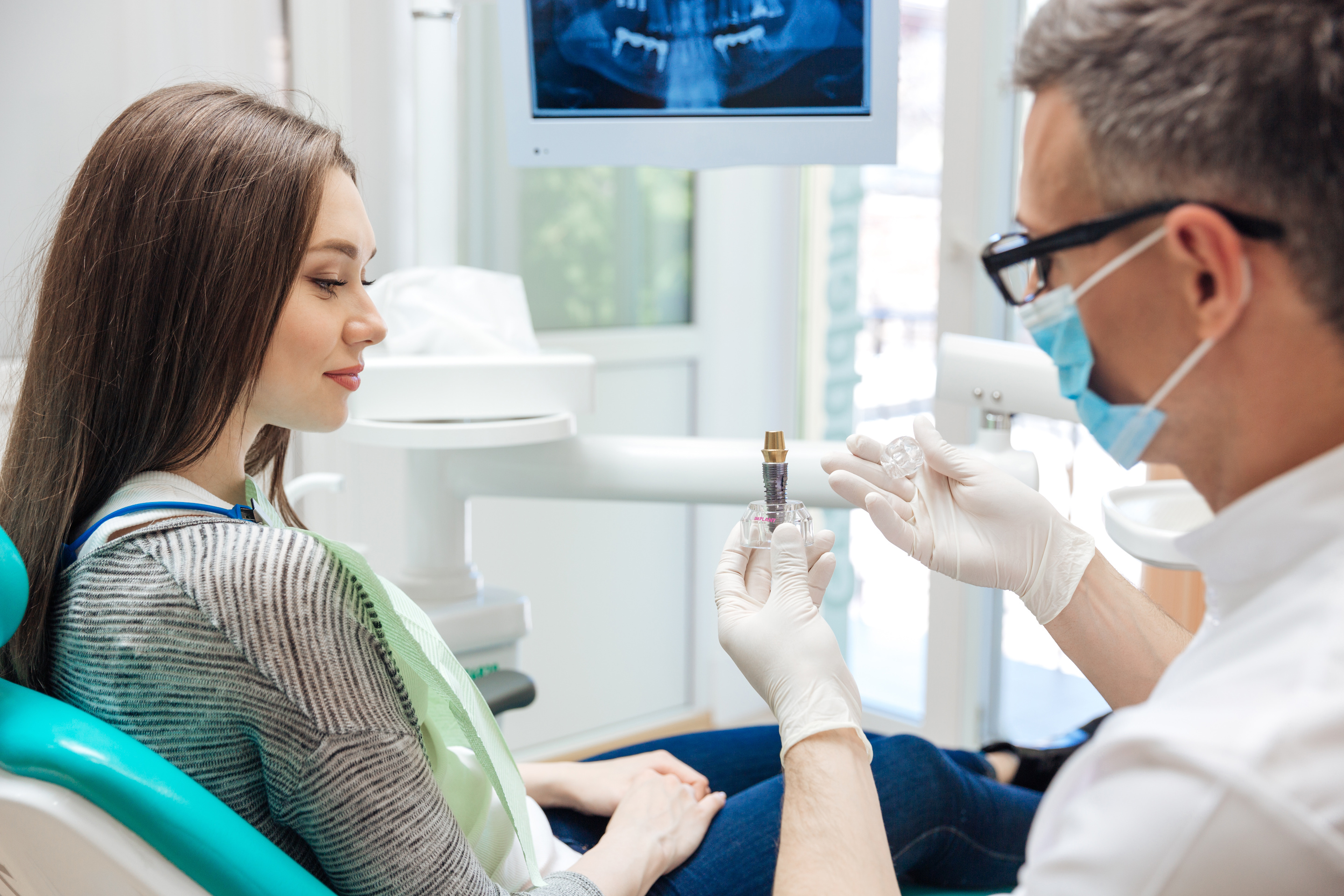 dentist showing patient dental implant North Jacksonville Complete