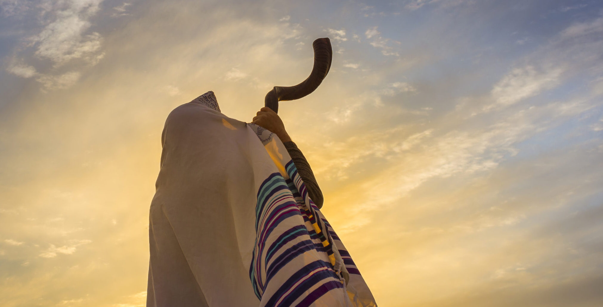 Blowing the Shofar man in a tallith, Jewish prayer shawl is blowing