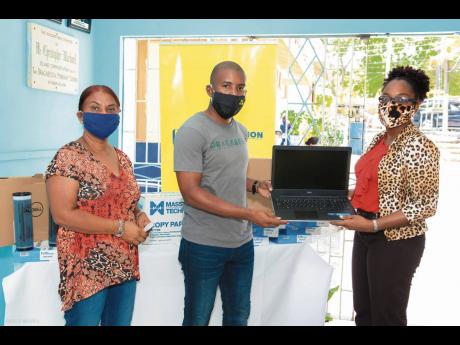 Travis Graham (centre), executive director, Oracabessa Foundation, hands over two laptops to Natricia Lothian (right), principal, Oracabessa Primary and High School. NCB Foundation has partnered with Oracabessa Foundation to assist its COVID-19 Education Support Initiative to provide the Oracabessa Primary and High School with two brand new laptops, along with printing supplies. The donations of the laptops, printer ink and paper has helped the school to serve its student population better. Looking on is Brenda Angus, board member, Oracabessa Foundation.