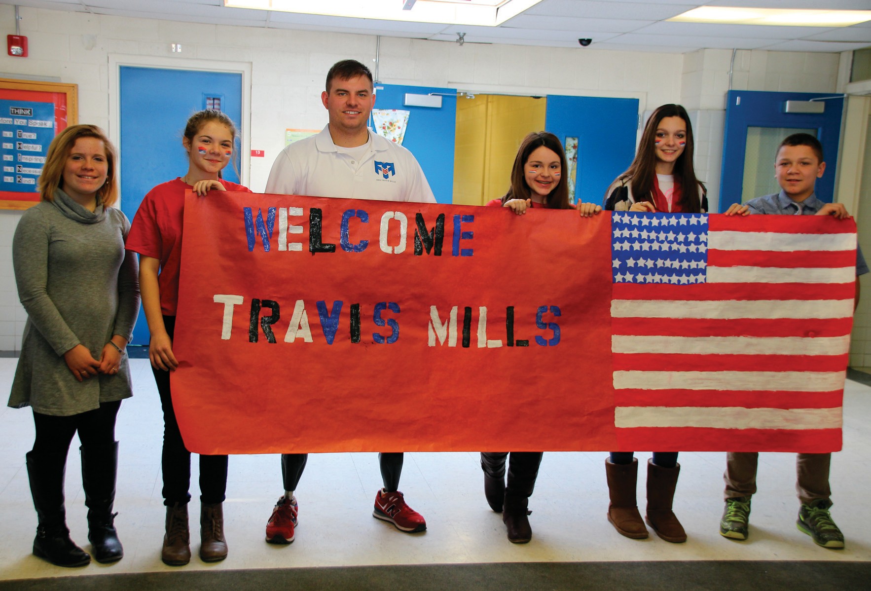 Motivational speaker Travis Mills, a retired U.S. Army staff sergeant who lost his limbs when a bomb explored in a roadway during his third tour of Afghanistan, and who formed a foundation to help other soldiers in similar circumstances, spoke to students at Sanford Junior High School Thursday. He stopped to pose with students who greeted him at the door. Left to right are Jasmine Soucy, Ashley Hartnett, Mills, Catlyn Marcotte, Jillian Sadick and David Jones.