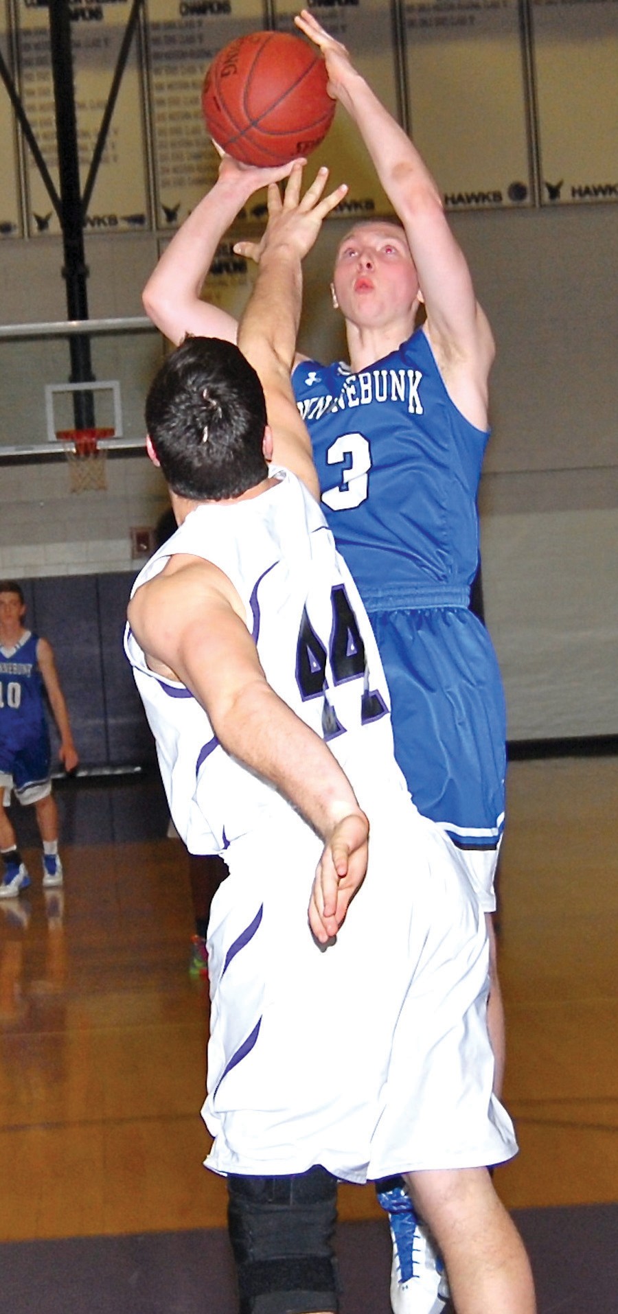 Kennebunk senior Zach MacKinnon shoots over a Marshwood defender during Tuesday’s playoff game. MacKinnon led the Rams with 17 points.