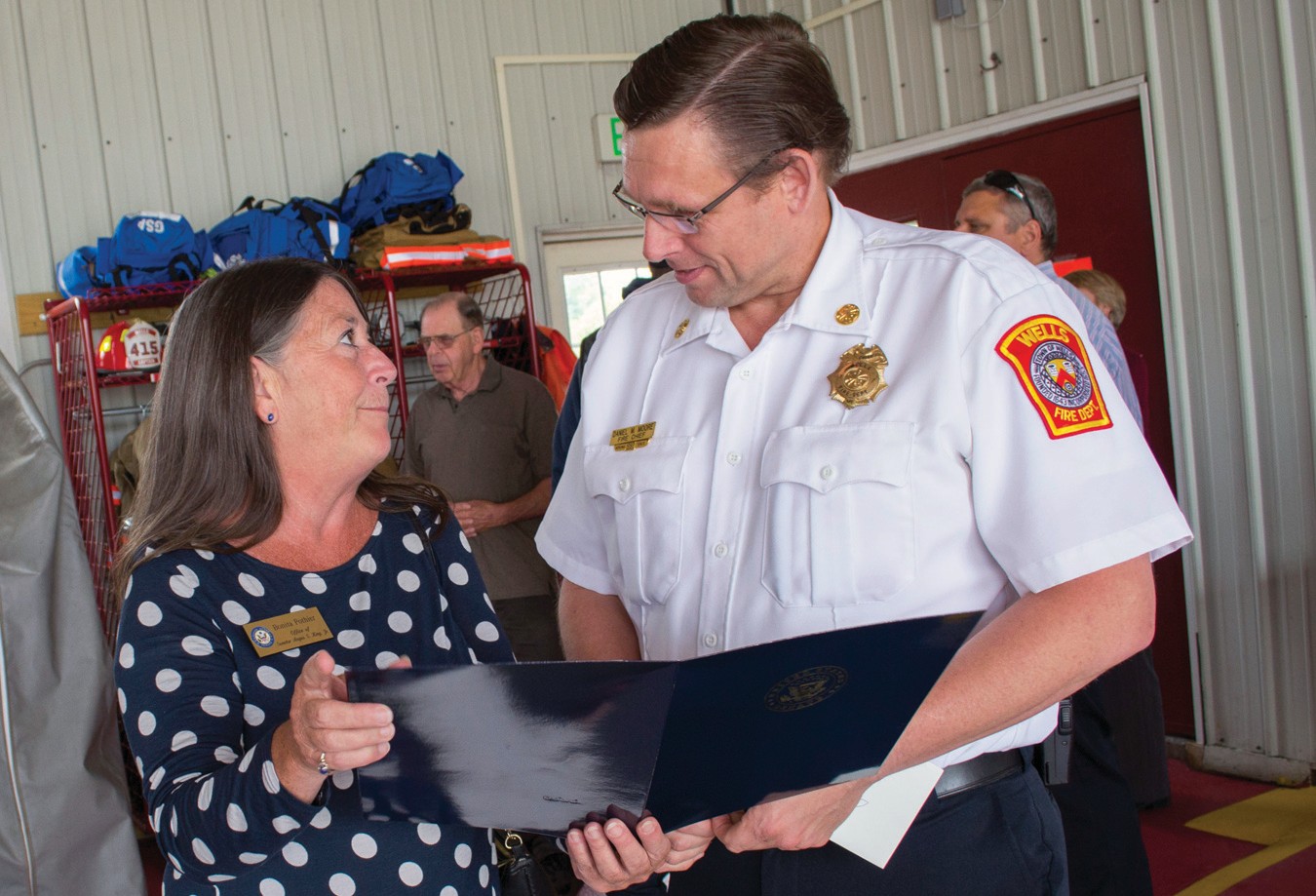 Bonita “Bonnie” Pothier, Scarborough regional representative for U.S. Sen. Angus King, presents retiring Wells Fire Chief Daniel Moore with a letter from the senator at a celebration in his honor on Wednesday, thanking him for his 34 years of service.