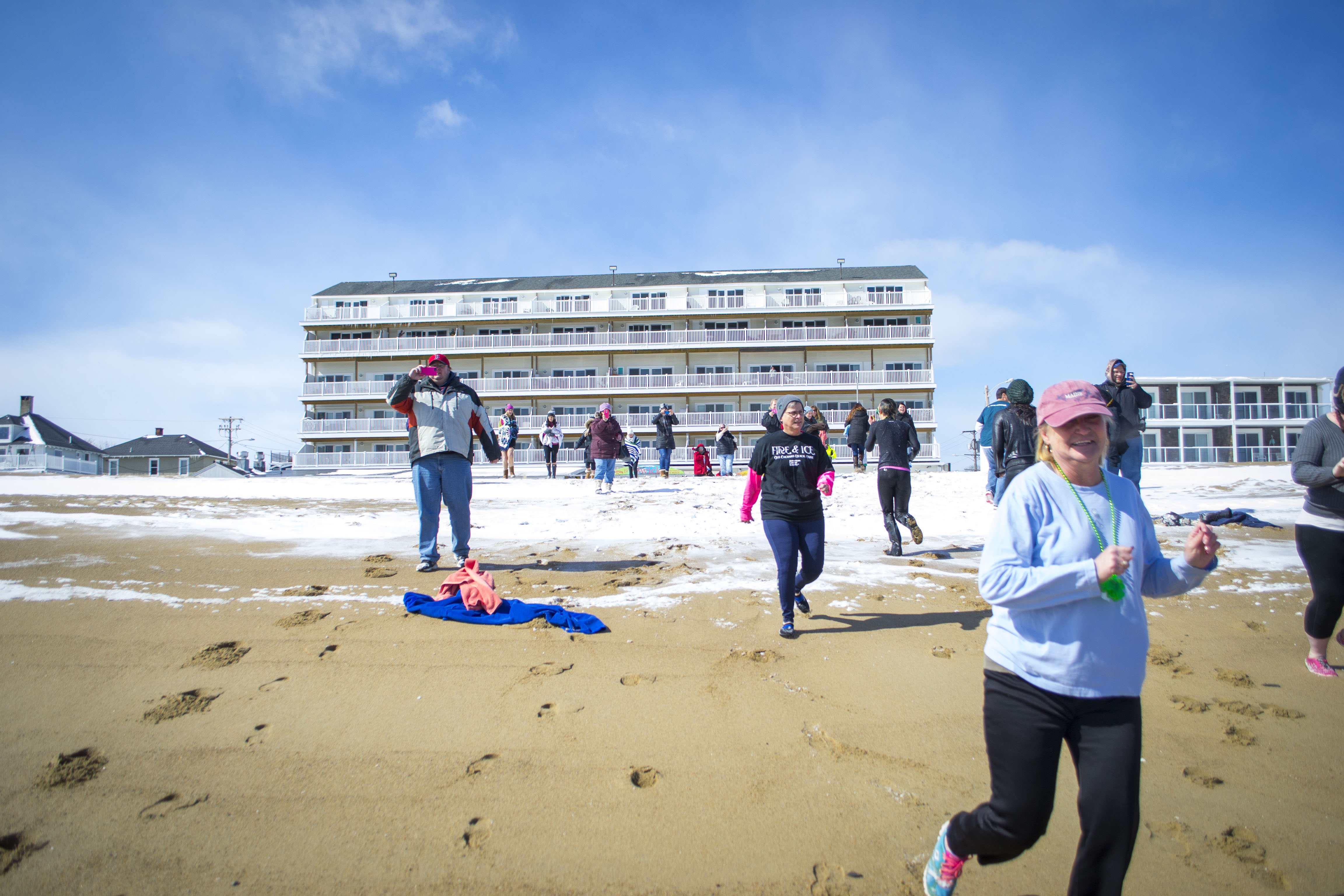 About 20 polar dippers run toward the ocean at The Brunswick Resort in Old Orchard Beach on Saturday, bringing awareness to cancer research at an event to benefit the American Cancer Society. ALAN BENNETT/Journal Tribune