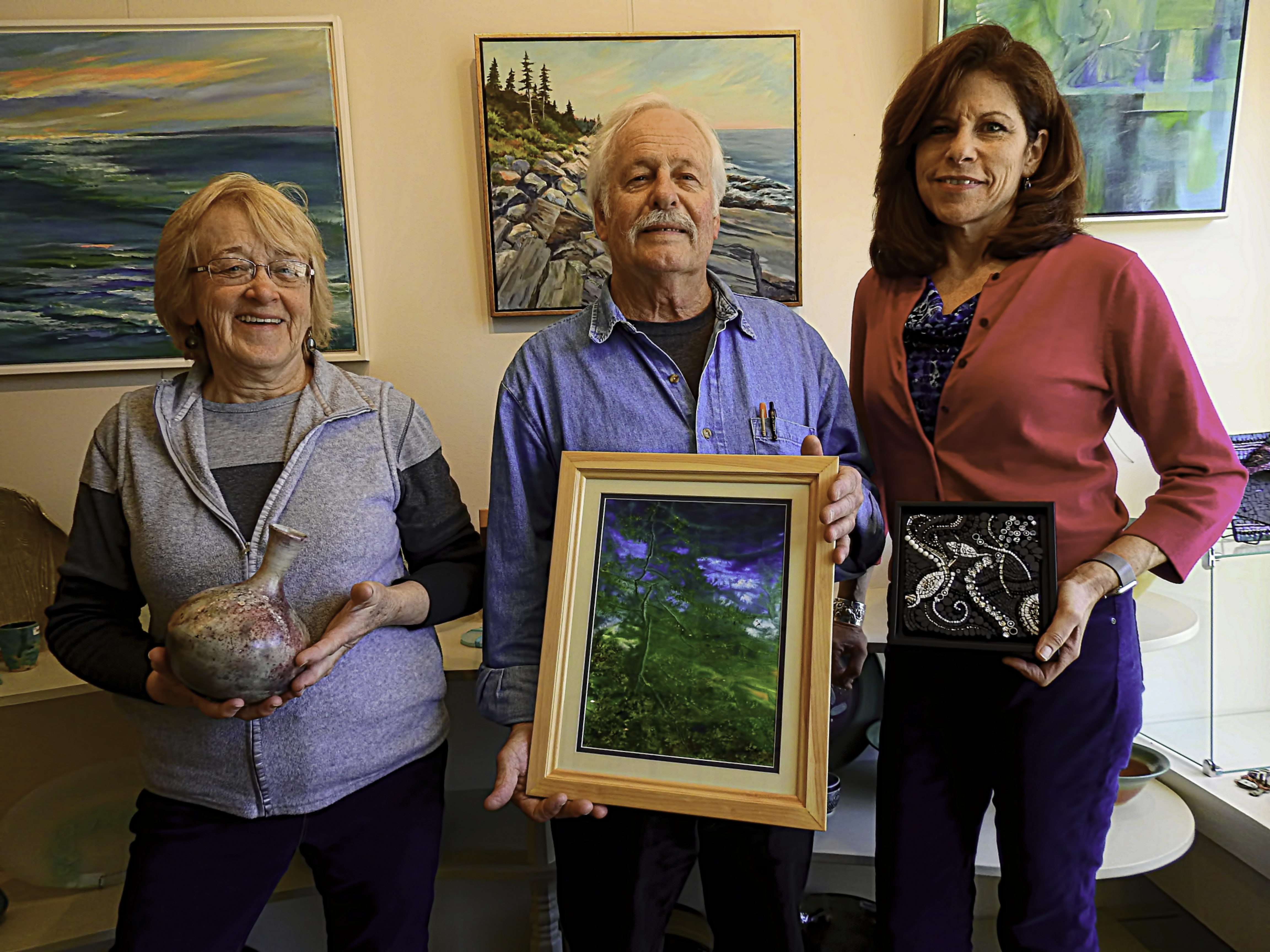 The three principals in The Green Heron, Kathleen King, Roger Dearborn and Nancy Maloney standing in the Gallery with samples of their artwork.