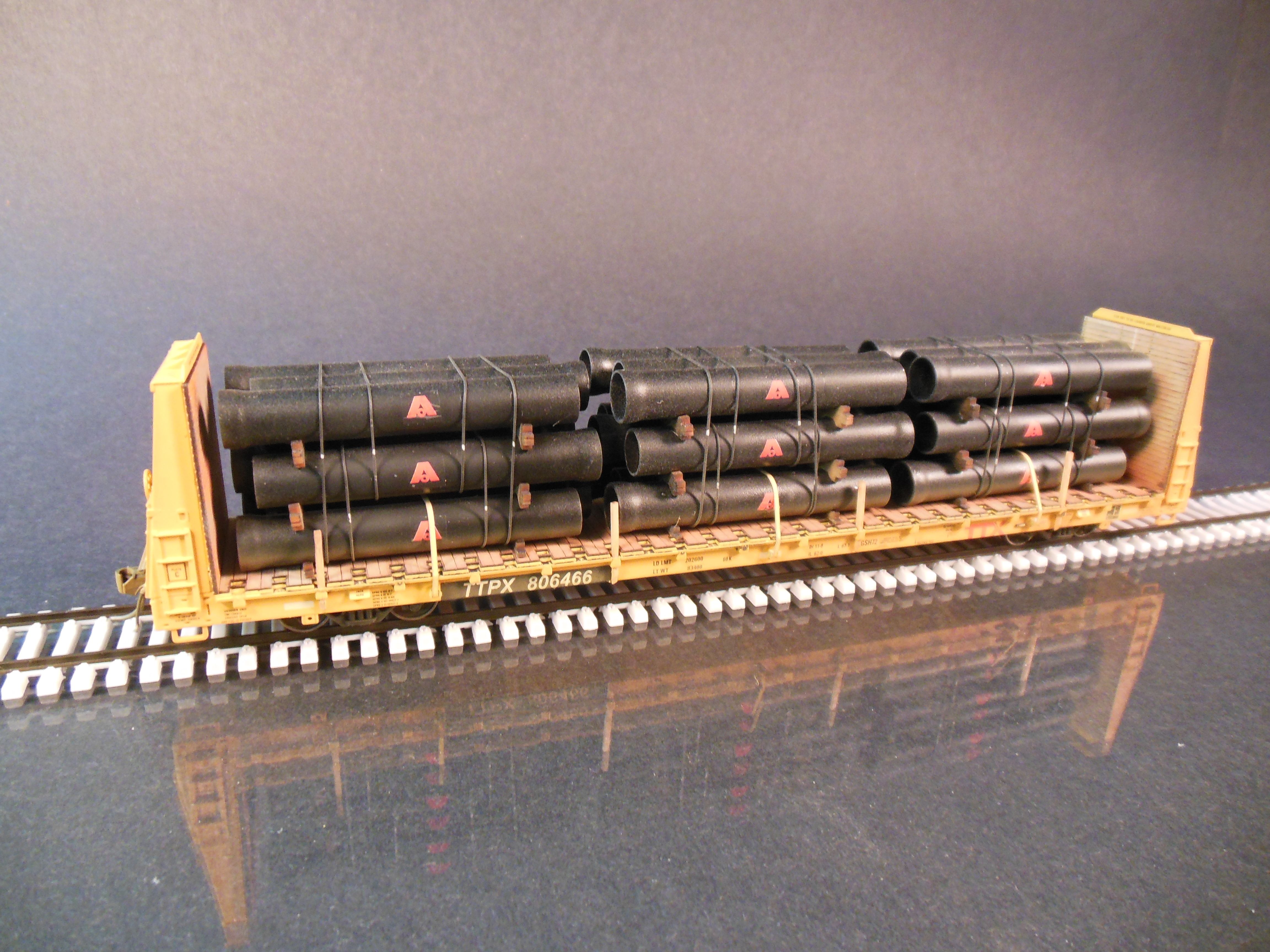 Atlas HO bulkhead flatcar with ductile iron pipe. Protoloads