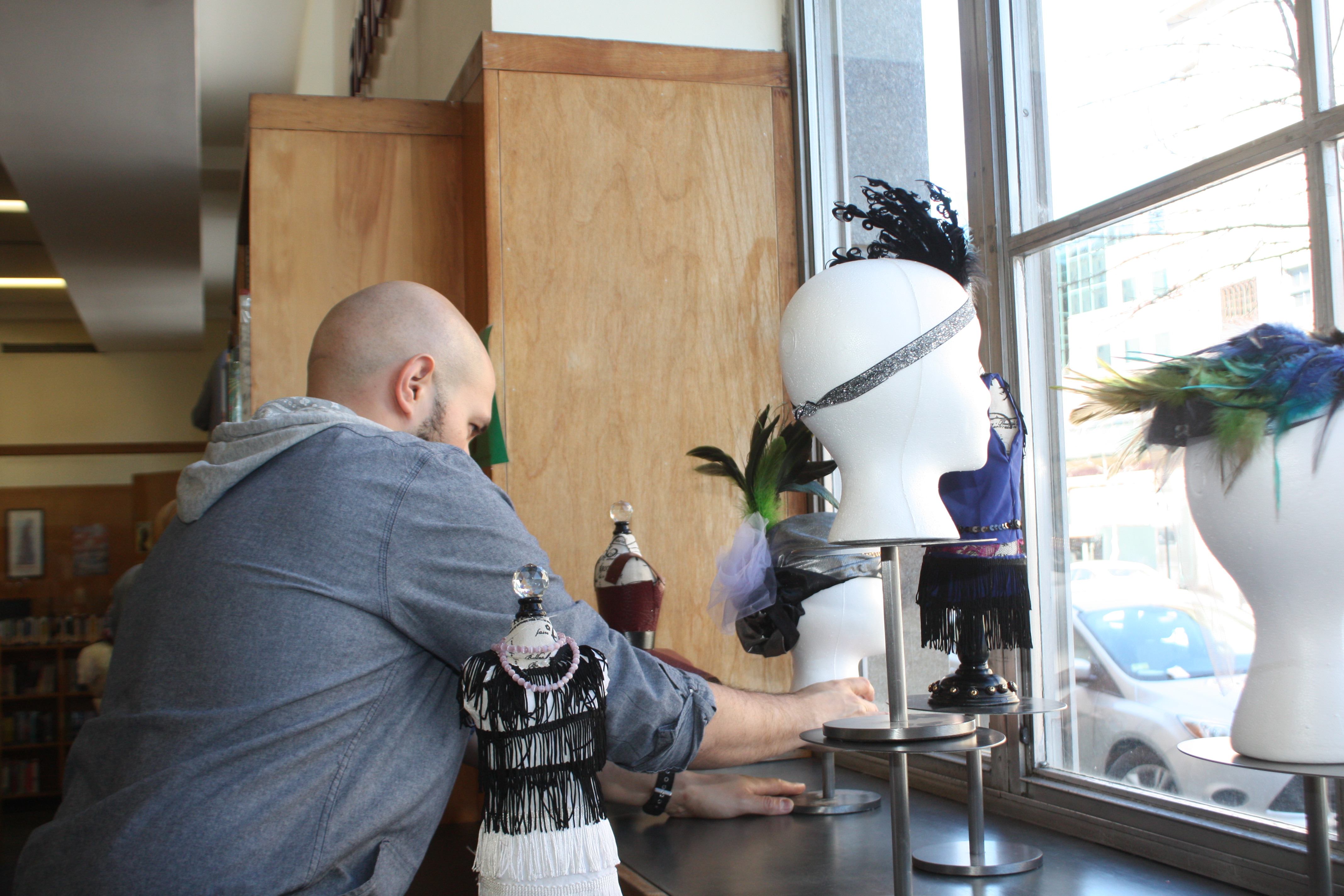 A window display designer setting up a display at Providence Public