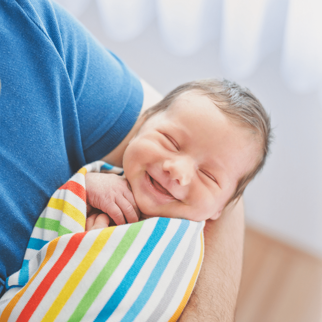 cute baby smiling wrapped in rainbow blanket Rainbow Fertility
