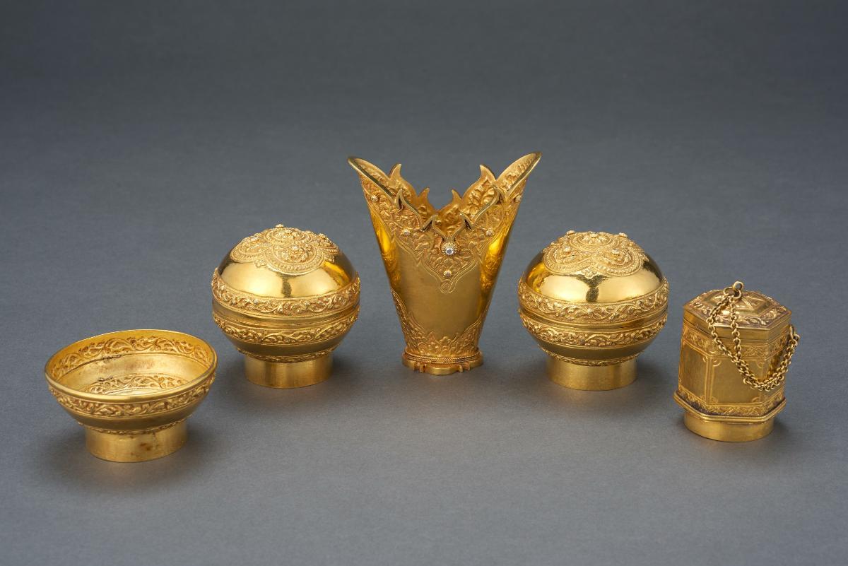 A set of gold sireh containers.