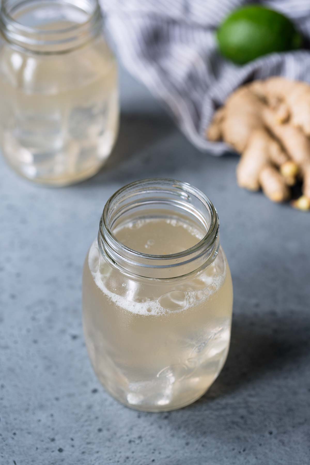 A close up of homemade ginger ale on a stone backdrop.