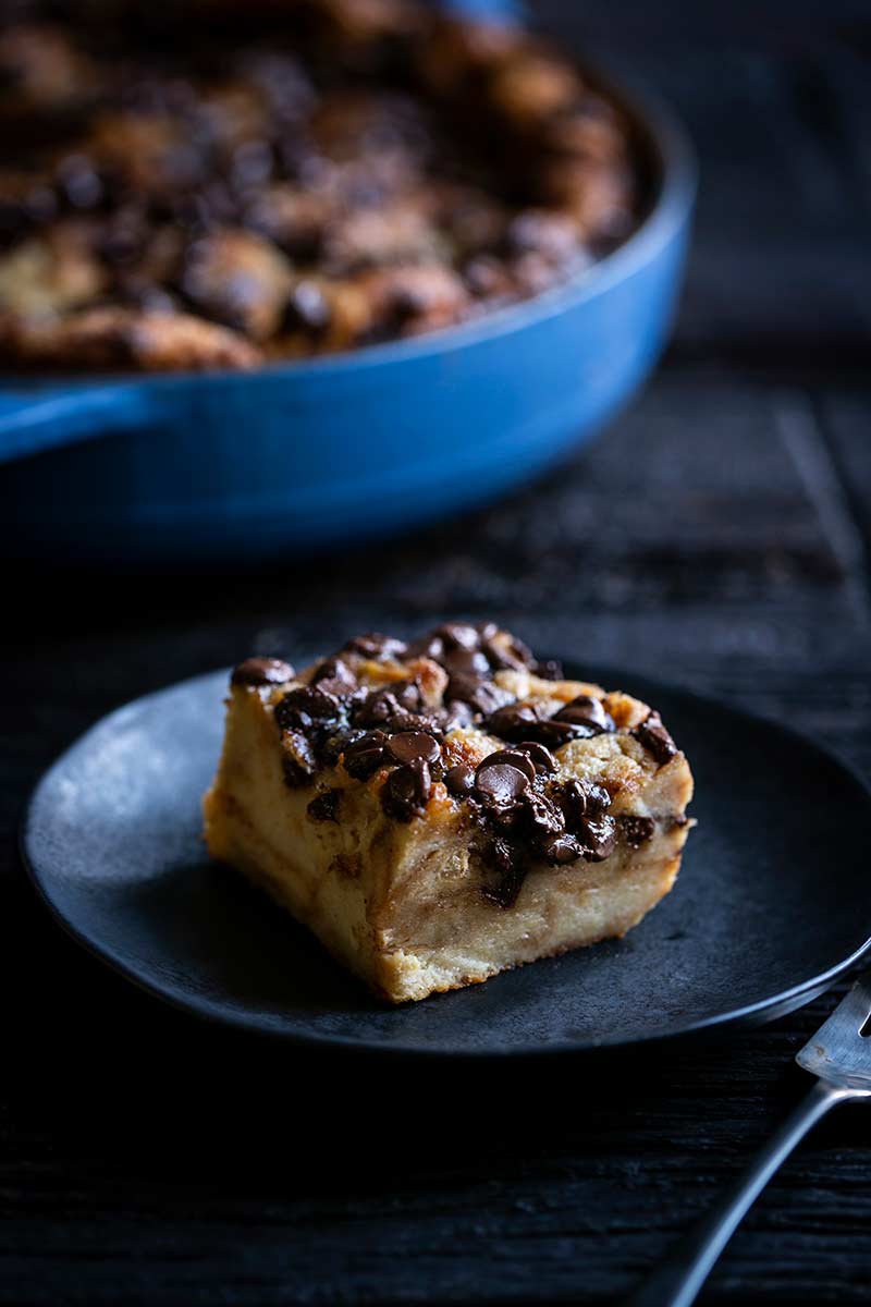 A slice of chocolate croissant bread pudding on a plate.