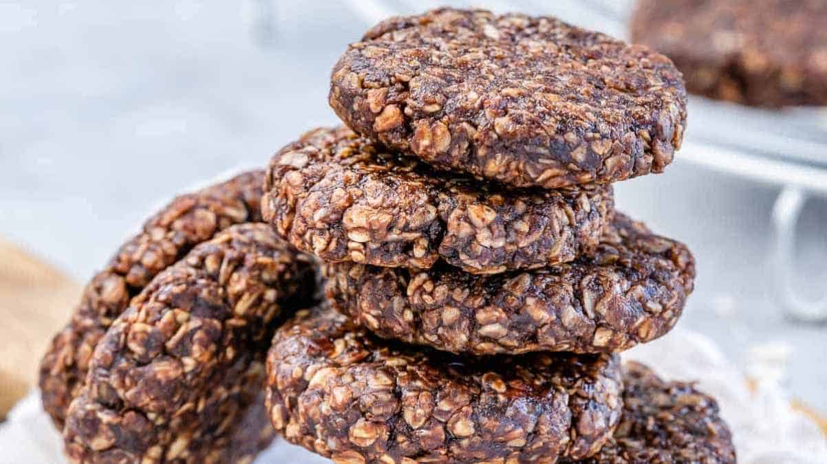 A stack of chocolate oat cookies on a wooden board.