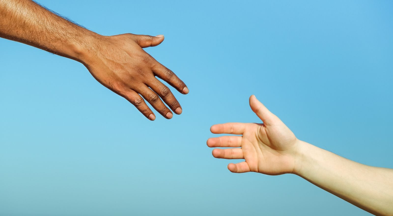 Black hand man helping white person Different skin color hands South Peninsula Hospital