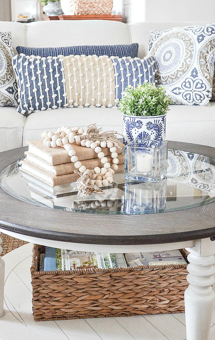 ROUND COFFEE TABLE WTH BURLAP BOOKS AND OTHER ACCENT DECOR ON IT