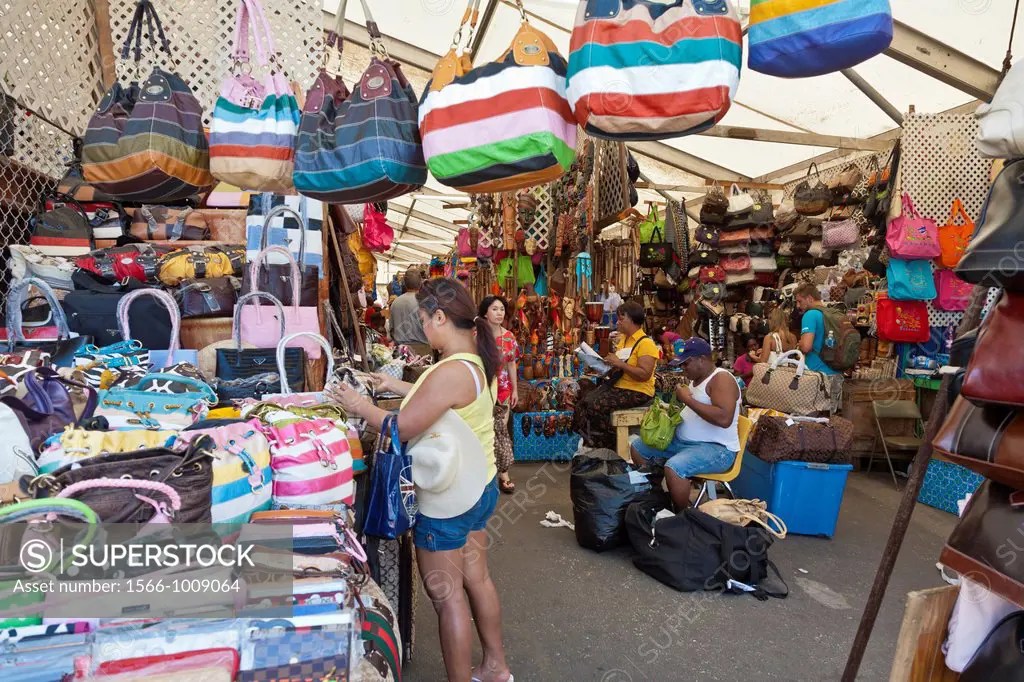 Men and women tourists shop in the crowded Straw Market for gifts and