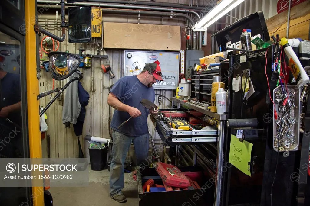 West Branch, Michigan School bus mechanic in the bus garage at