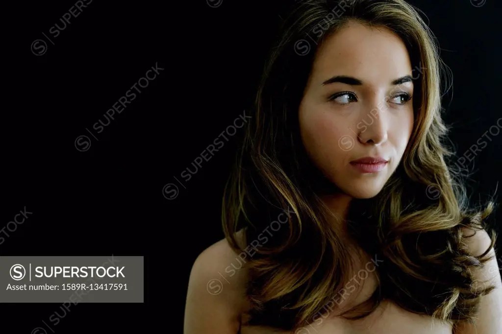 Portrait of serious naked Hispanic woman - SuperStock