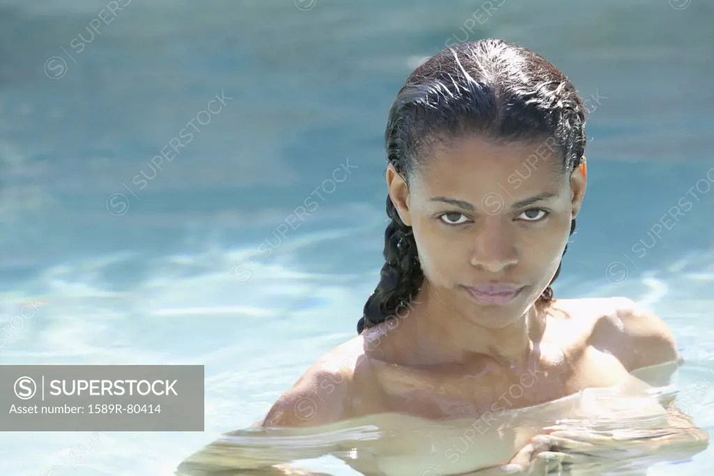 Nude mixed race woman in swimming pool - SuperStock