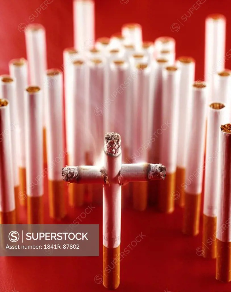 Closeup of cross made by cigarettes SuperStock