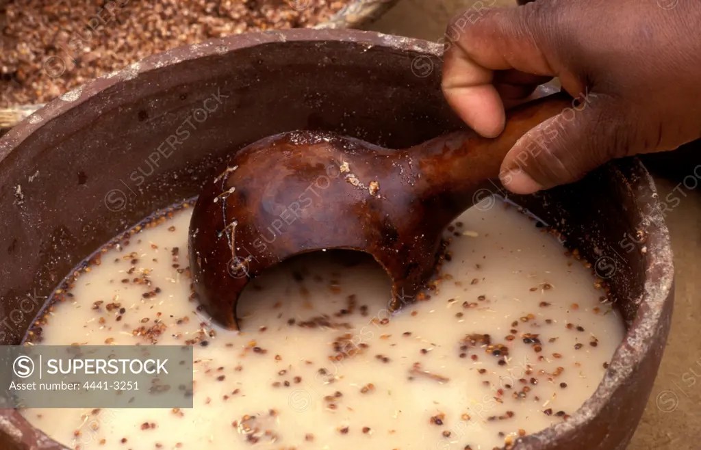 Zulu beer making. Scooping mixture into a calabash. Shakaland