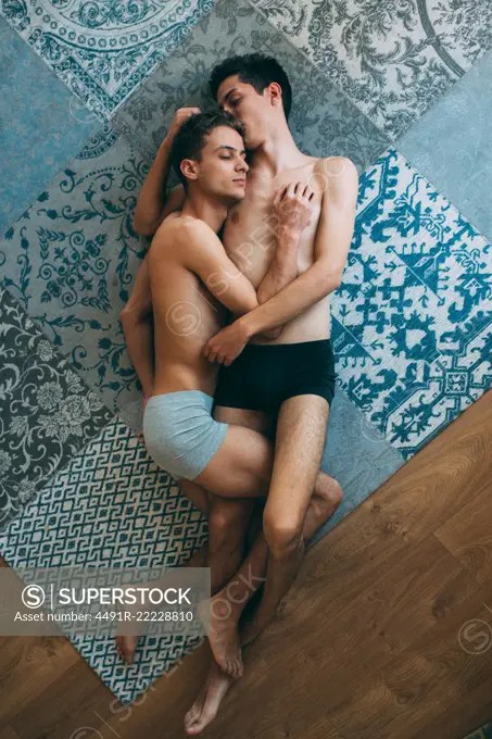 Passionate sexual naked gay couple in an intimate moment lying down in