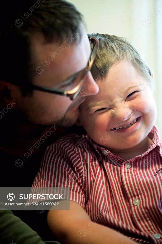 a child suffering from downs syndrome, with his father. SuperStock