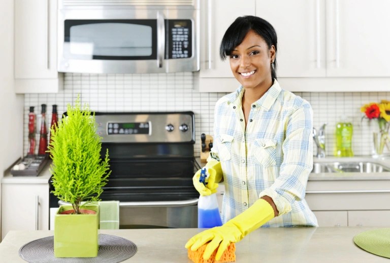 Young woman cleaning kitchen Sweep Home Chicago
