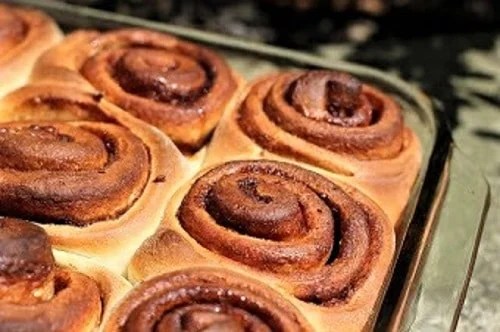 Sweet, tender classic cinnamon rolls - dripping with icing, these cinnamon buns will start your morning on a delicious note! Cinnamon Buns in a baking dish without frosting
