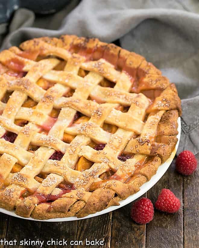 Lattice Topped Peach Raspberry Pie - a delectable summer fruit dessert! Peach Raspberry Pie in a white pie plate.