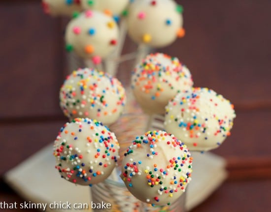 White Chocolate Dipped Cheesecake Pops - an exquisite, bite-sized treat! Cheesecake Pops covered with sprinkles