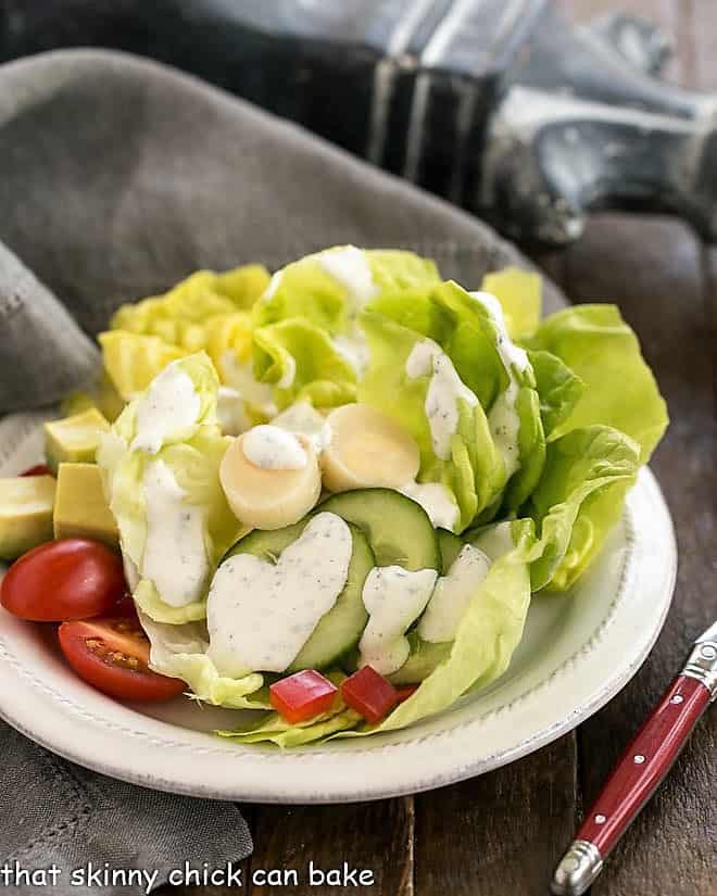 Homemade Ranch Dressing - Made with fresh herbs and wholesome ingredients, the perfect salad topping! The Ultimate Ranch Dressing on a round white salad plate.