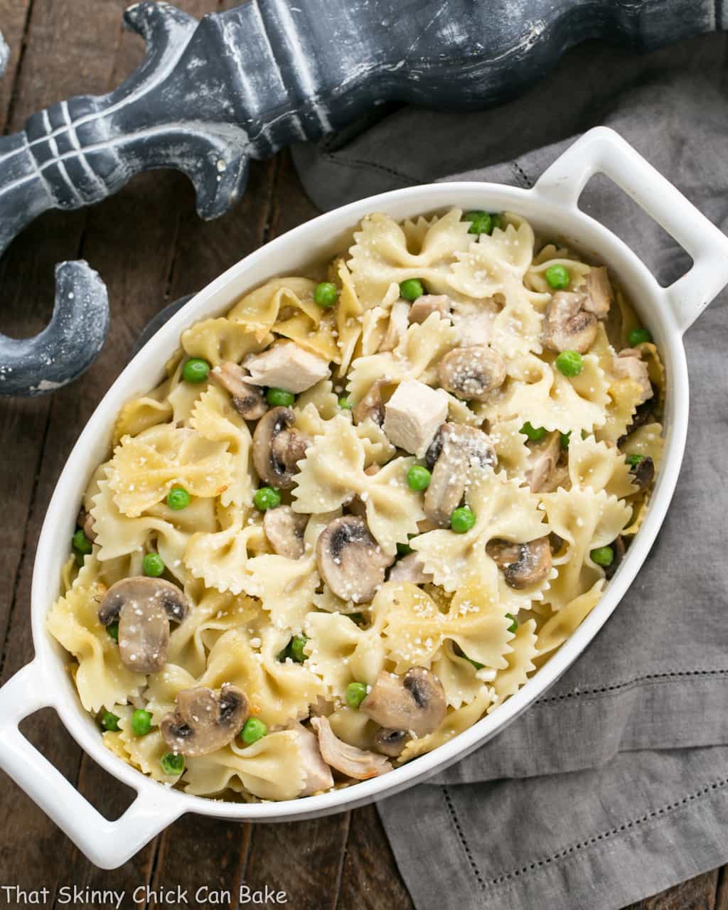 Turkey Tetrazzini Recipe - Comfort food with leftover poultry, peas, mushroom and a dreamy cream sauce! A perfect turkey leftovers recipe!! Overhead view of leftover turkey dish in an oval white casserole.