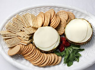 Best Pesto Dip Recipe - a delicious appetizer recipe with an Italian flair Overhead view of layered Italian dip on a tray with crackers