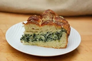 Italian Spinach Tart - a cheesy stuffed bread that's both comforting and delicious Slice of spinach tart on a white plate.