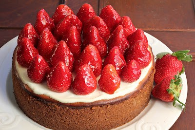 A rich and creamy Strawberry Topped Cheesecake topped with luscious ripe strawberries! strawberry topped cheesecake on a white plate