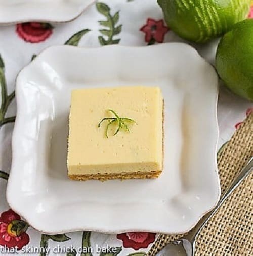 Sweet, tart, delicious Key Lime Pie Bars with a coconut crust! Overhead view of square of key lime pie bars on a white plate