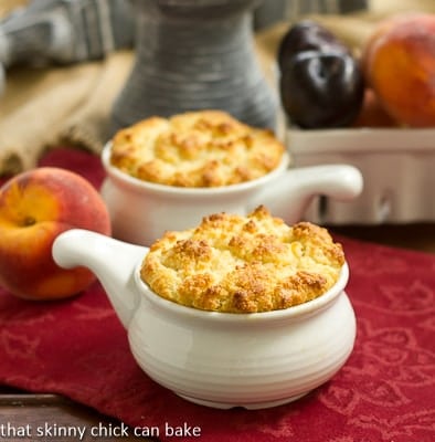 Peach and Plum Johnnycake Cobblers - a rustic cobbler with a corn meal biscuit topping Peach and Plum Johnnycake Cobblers in white ceramic baking dishes.