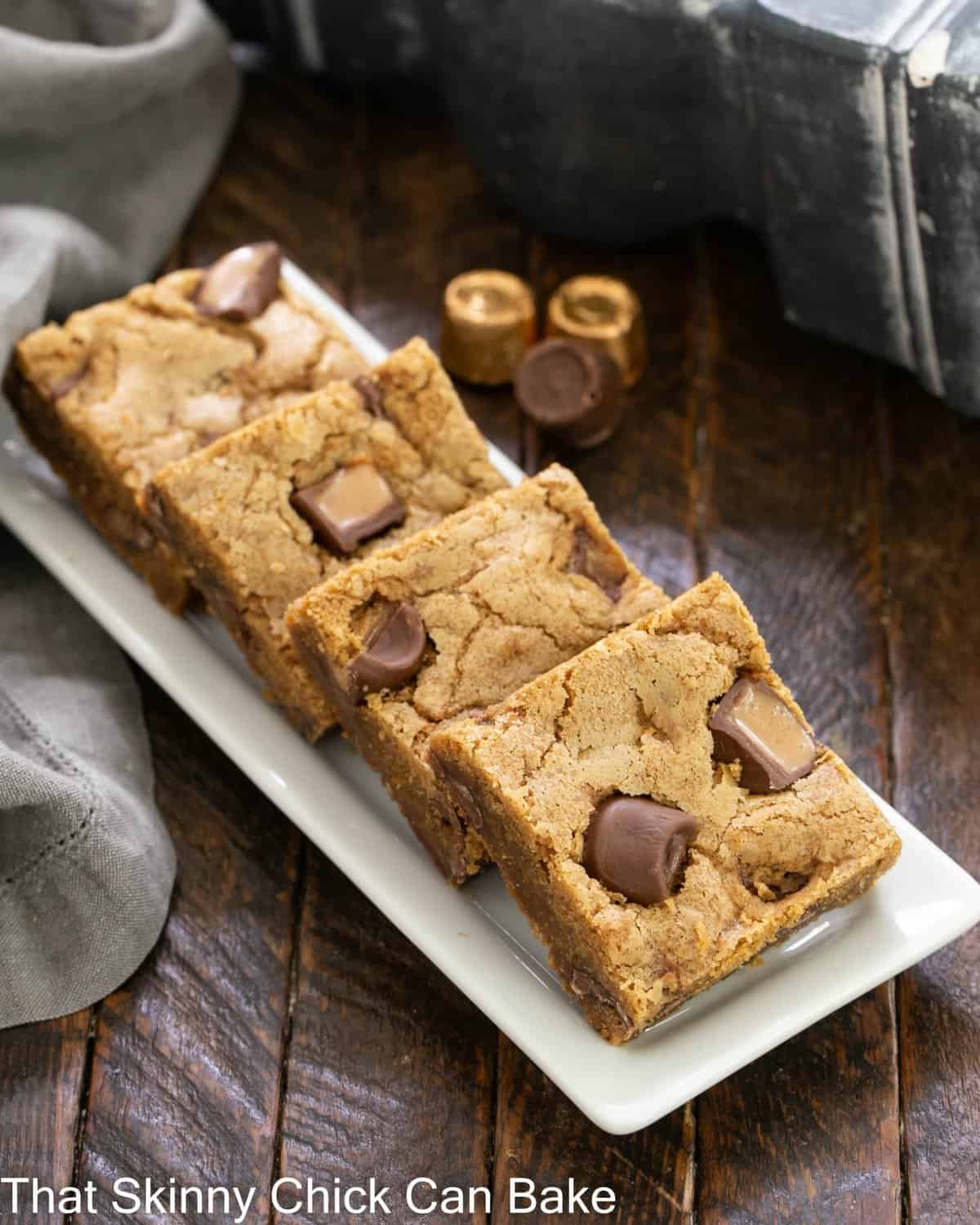 Biscoff Rolo Bars - Irresistible bars with Biscoff, Caramel and Chocolate! 4 biscoff rolo bars on a white ceramic tray.
