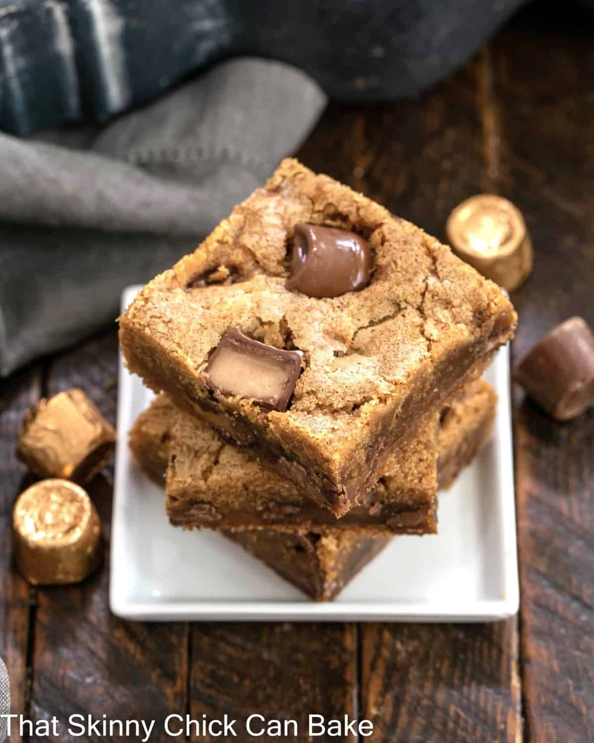 Biscoff Rolo Bars - Irresistible bars with Biscoff, Caramel and Chocolate! Stack of 3 Biscoff Rolo Bars on a small square white plate.