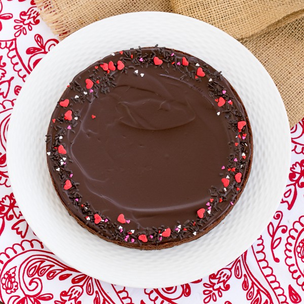 These rich, Ganache Topped Truffle Brownies are the perfect treat for when those chocolate cravings hit! Ganache Topped Truffle Brownies on a white ceramic plate.