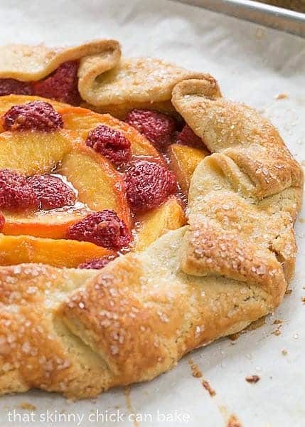 Peach Raspberry Galette - A rustic tart that's so much easier to make than pie! Peach Raspberry Galette on a parchment lined baking sheet.