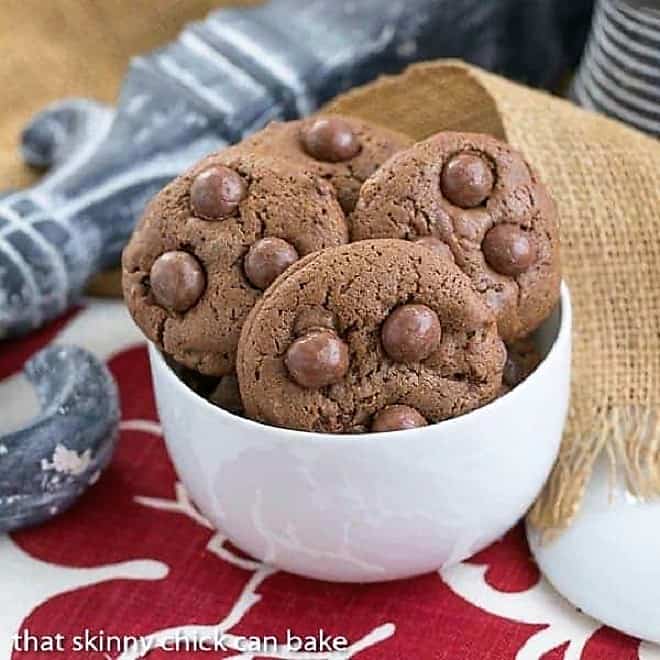 Whopper Cookies - Chocolate malt cookies studded with malted milk balls Whopper Cookies in a white bowl sitting on a red and white napkin.