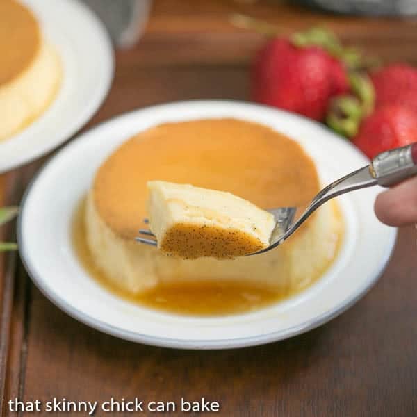 Mini Vanilla Flans - The classic Spanish custard and caramel dessert in individual servings! Forkful of mini vanilla flans with mini flan on a white plate in the background.