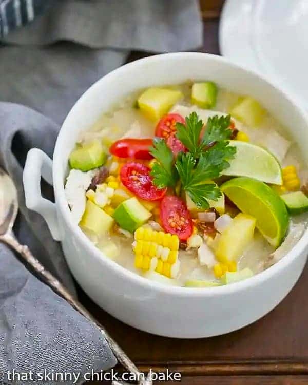 Bacon Corn Chowder - A summer soup full of corn, potatoes, chicken and smoky bacon! A white soup tureen filled with corn chowder.